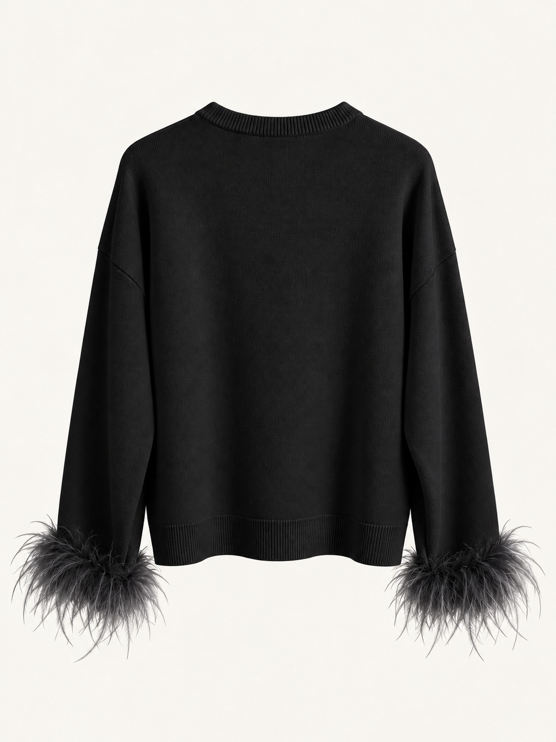 Maglia nera con piume ai polsi