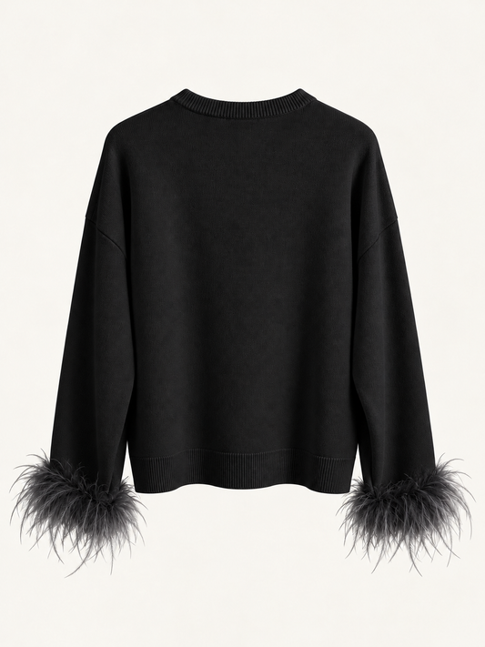 Maglia nera con piume ai polsi