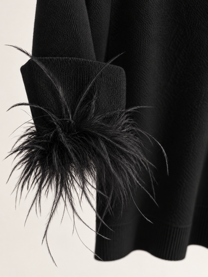 Maglia nera con piume ai polsi